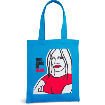 Blue tote bag with a graphic of a woman's face and text on a white Canvas tote featuring the poster art from the film TODO SOBRE MI MADRE by Pedro Almodóvar. Featuring the Academy Museum logo and is available exclusively at the Academy Museum Storebackground